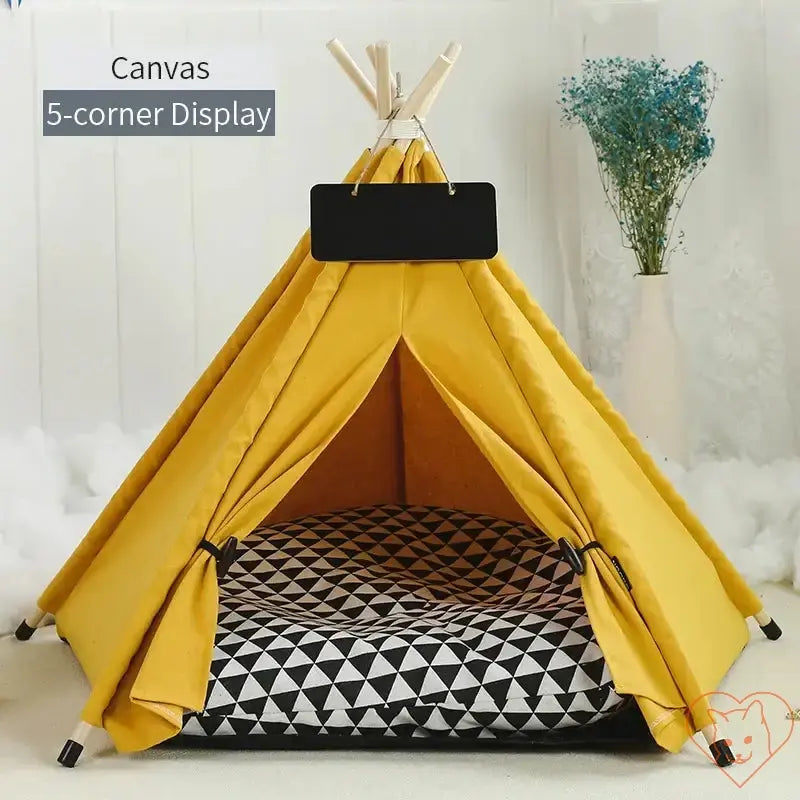 Stylish yellow canvas cat teepee tent with geometric cushion for cozy relaxation.
