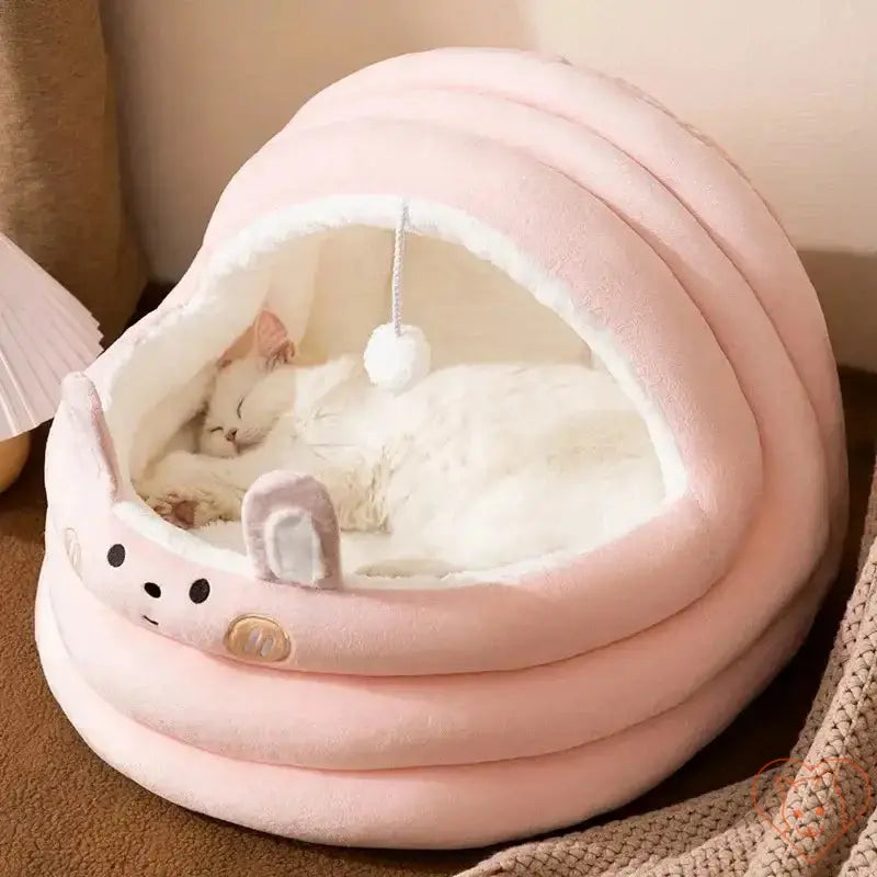Cozy pink semi-enclosed plush cat bed with a white cat sleeping inside, ideal for autumn and winter comfort.