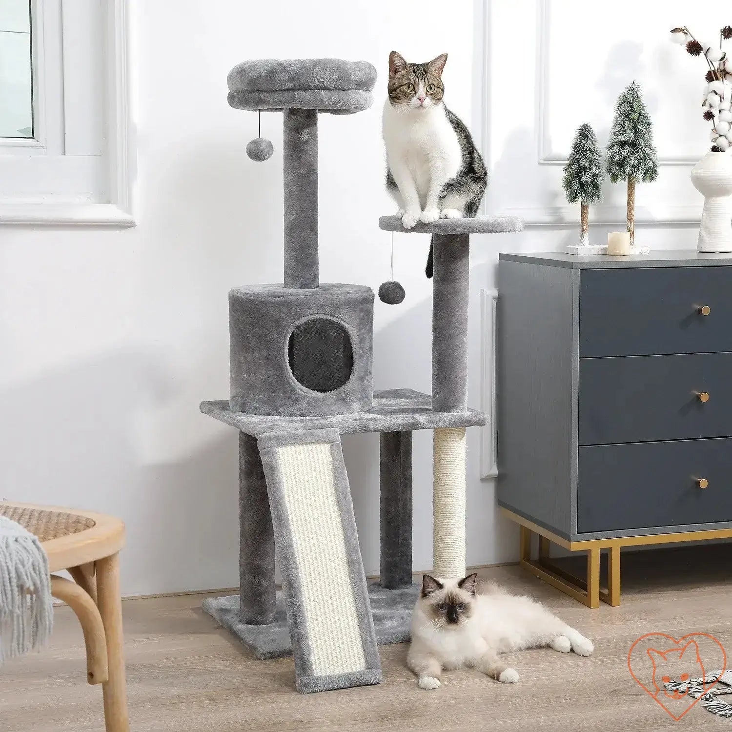 Two cats playing on a 68-inch multi-level cat tree with condos and scratching posts in a stylish room.