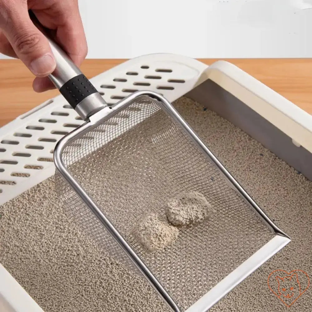 Person using an aluminum alloy cat litter scoop over a litter box to clean litter.