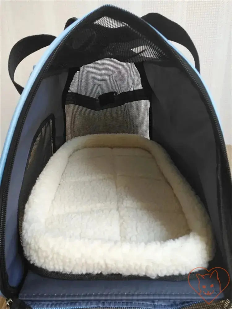 Inside view of a breathable pet travel bag featuring a soft cotton mat and mesh panels for optimal ventilation.