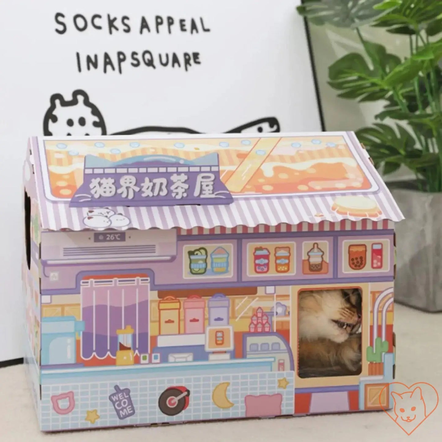 Cozy cardboard cat house with scratching pad, featuring colorful design and window for playful felines.