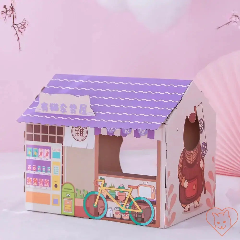 Colorful cardboard cat house designed like a cozy shop, featuring a bike and playful graphics for feline fun.