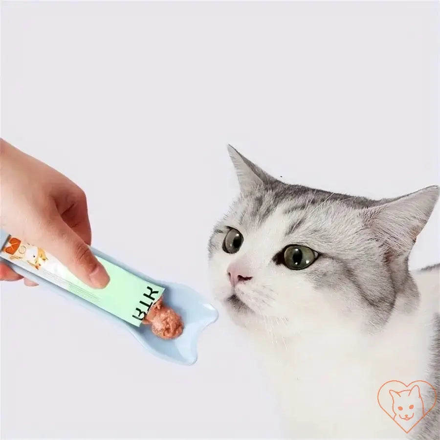 Cat eagerly approaching a hand-held feeding spoon with lickable treat on it, showcasing the Pet Supplies Cat Strip Feeder.