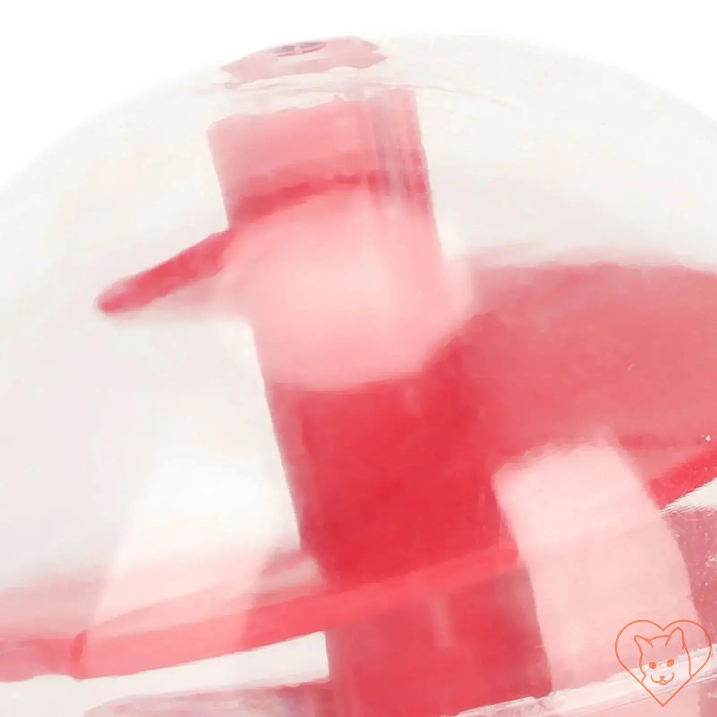 Close-up of a cat treat dispensing ball, featuring a transparent design with red accents for interactive play.