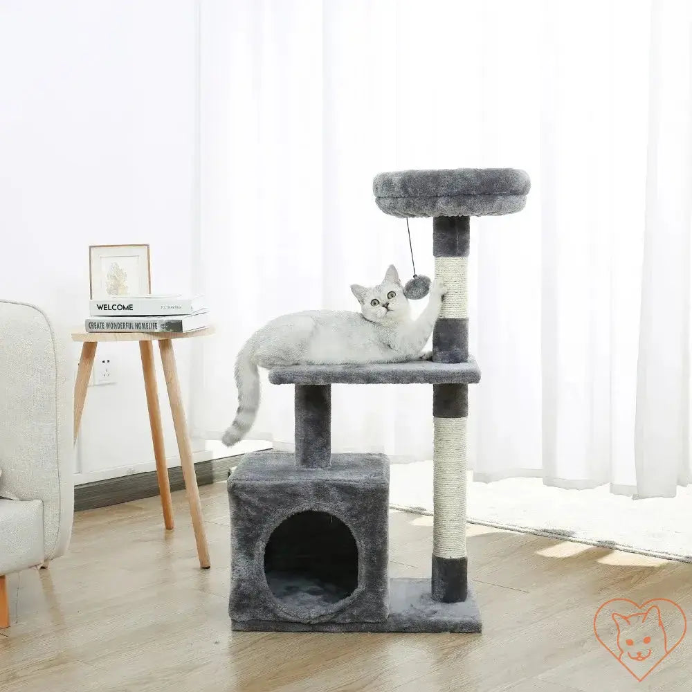 Multi-level cat tree house with scratching posts, featuring a playful cat lounging on top.