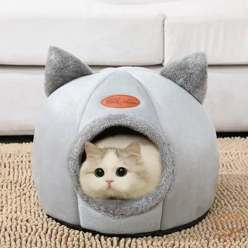 Cozy Winter Cat Cave Bed with soft ears, featuring a cat comfortably nestled inside on a rug.