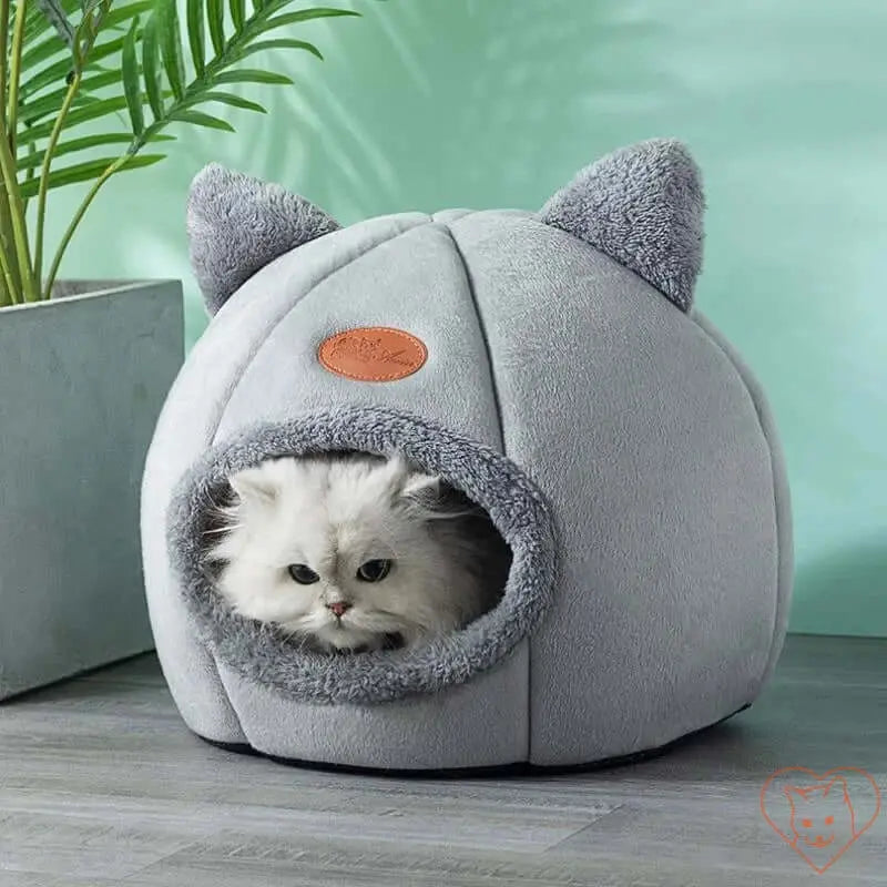 Cozy Winter Cat Cave Bed featuring a fluffy cat nestled in soft gray fabric with ears, providing warmth and comfort.