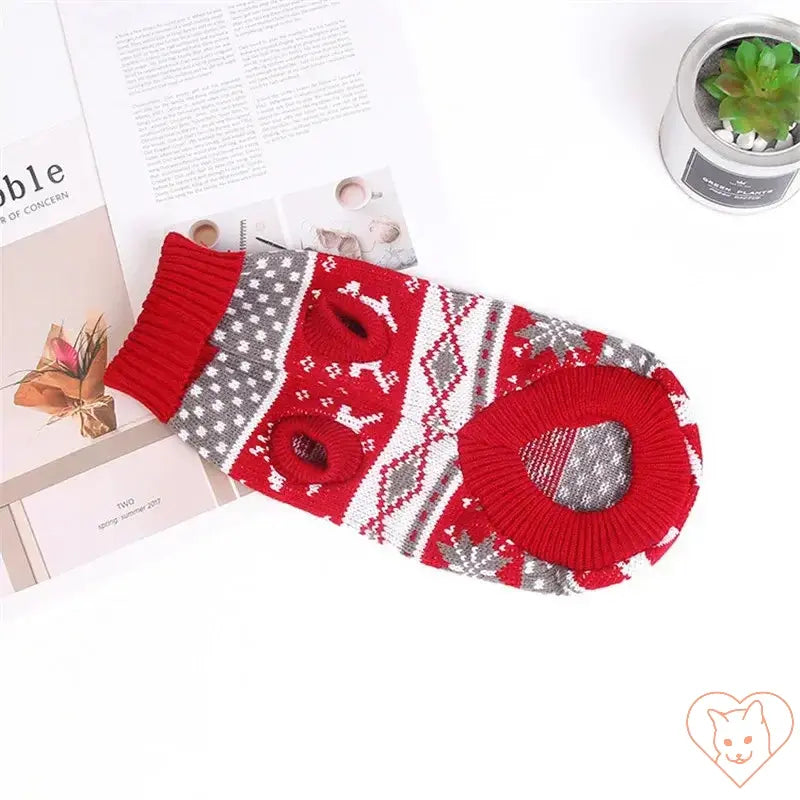 Cute cat sweater costume in red and gray with cartoon pattern on a flat surface; perfect for winter warmth.