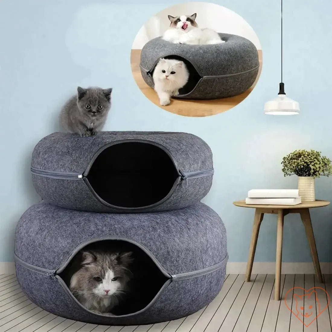 Two-layered donut cat bed with interactive tunnel, featuring playful cats inside and on top.