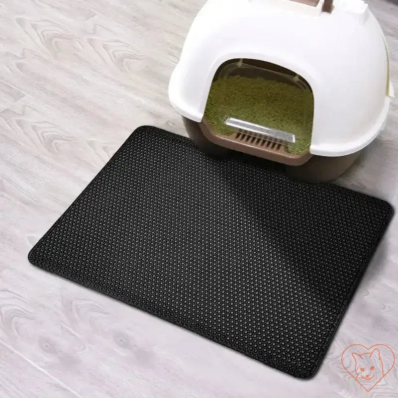 Double-layer waterproof cat litter mat placed near a cat litter box, effectively trapping litter and preventing mess.