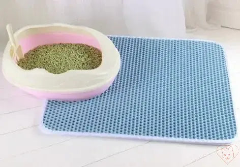 Double-layer waterproof cat litter mat beside a cat litter box, effectively capturing litter granules.