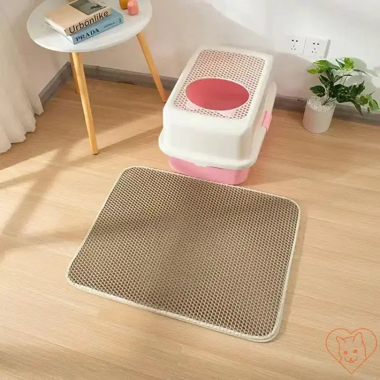 Double-layer waterproof cat litter mat positioned near a pink cat litter box on a wooden floor.