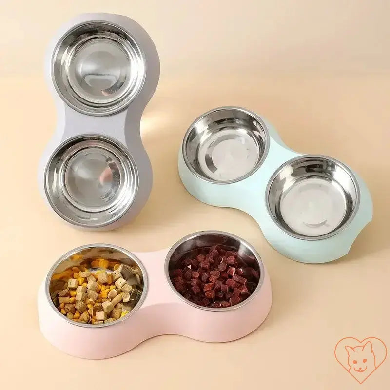 Double stainless steel pet food bowl in pink, blue, and gray with kibble and wet food.