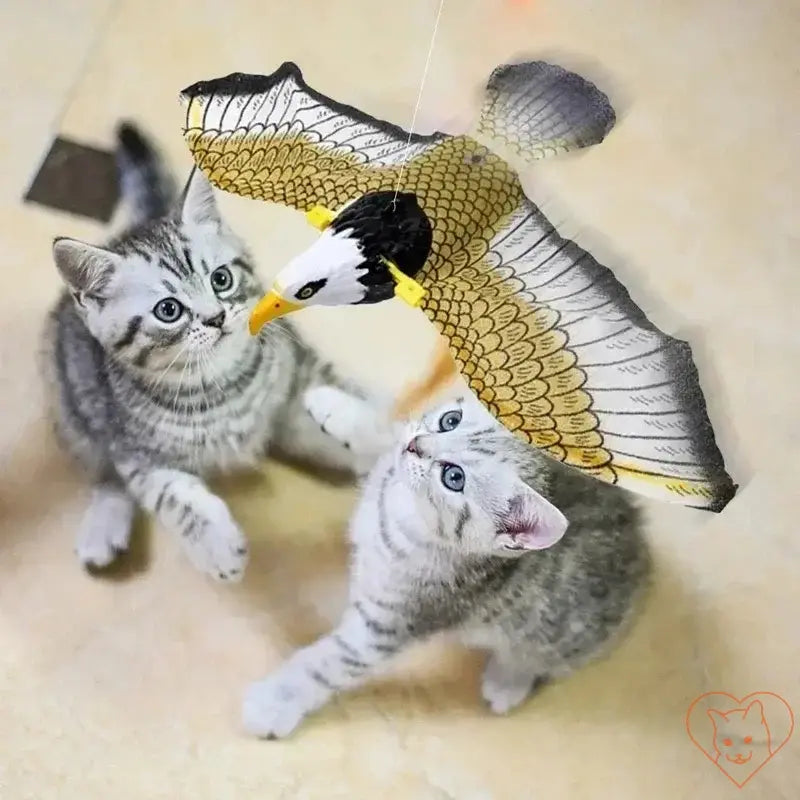 Two playful kittens engaging with an electric hanging bird cat toy, enhancing their natural hunting instincts.