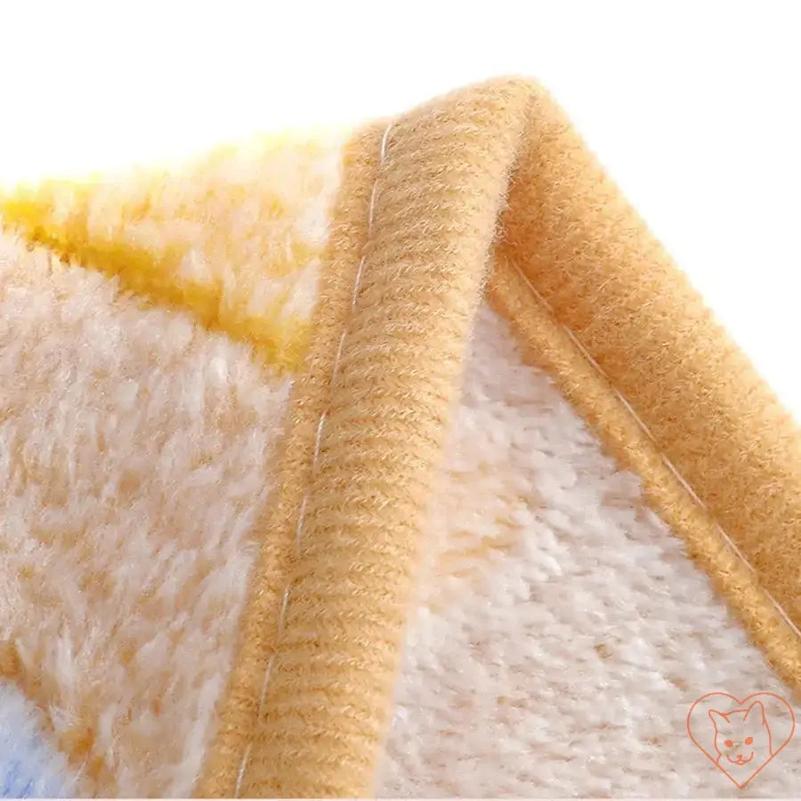 Close-up of the edge of a soft, flannel pet blanket showcasing its cozy texture and warm colors.