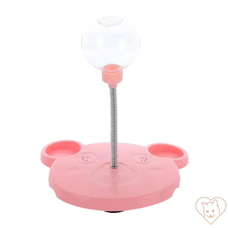 Interactive pet puzzle feeder toy in pink, featuring a suction base and transparent food chamber for cats and dogs.