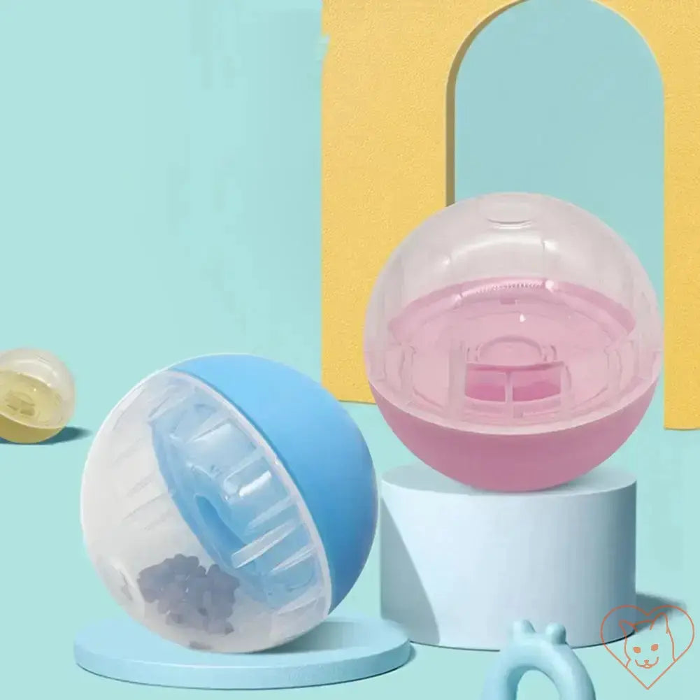 Interactive pet food balls in pink and blue for dogs and cats, designed as slow feeders and treat dispensers.