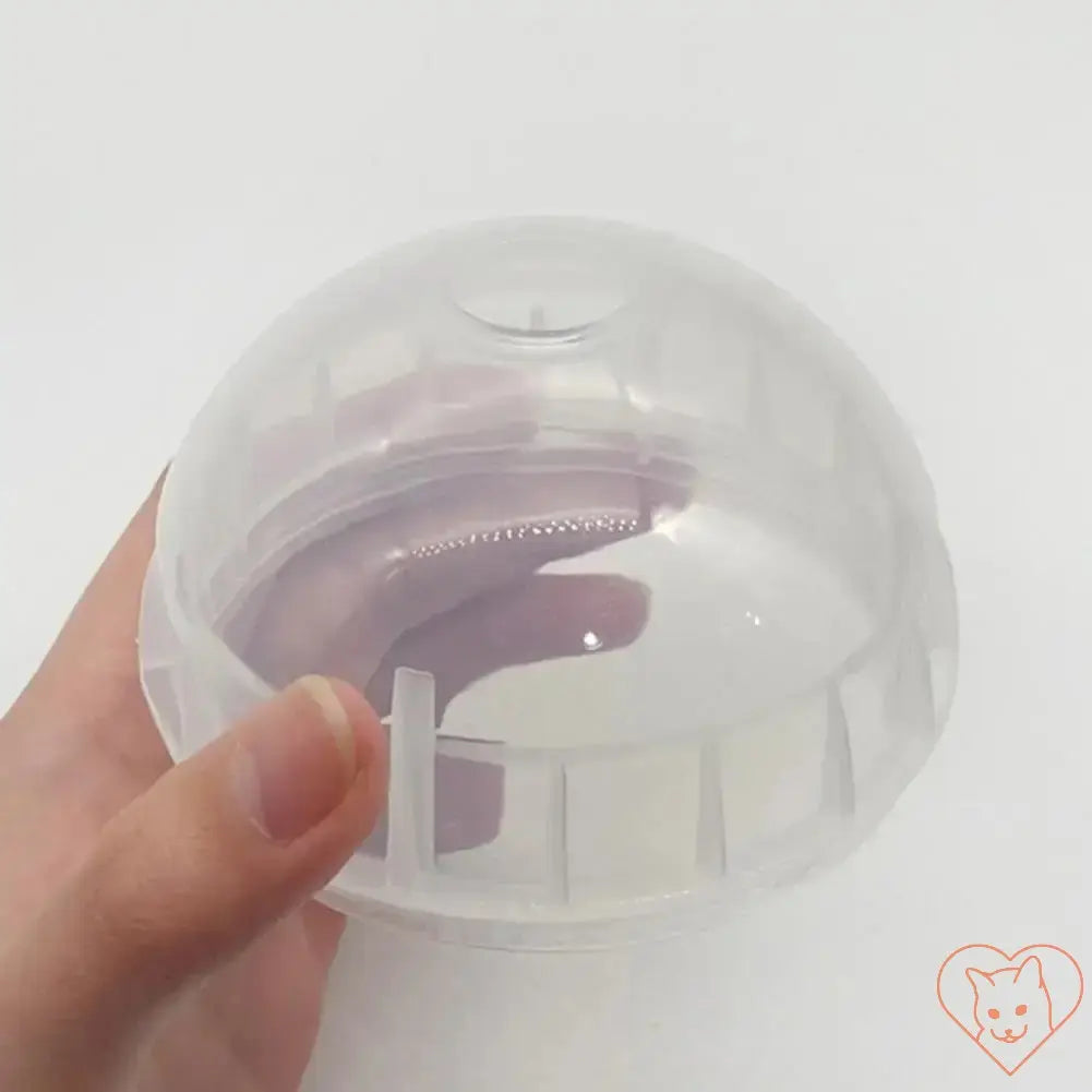 Clear plastic interactive food ball for dogs and cats, used as a slow feeder and treat dispenser.