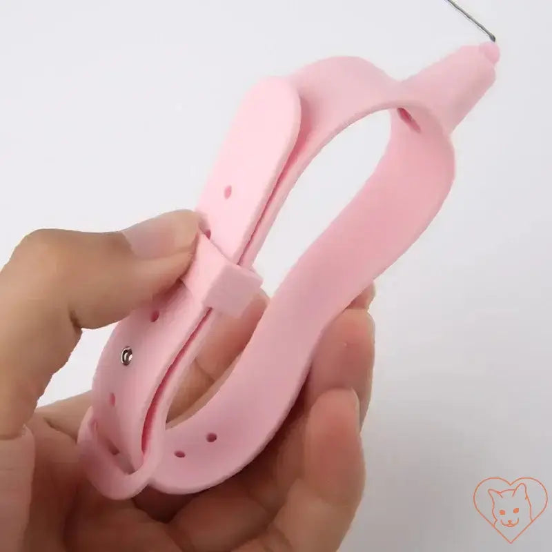 Hand holding a pink interactive cat toy strap designed for hands-free play with cats.