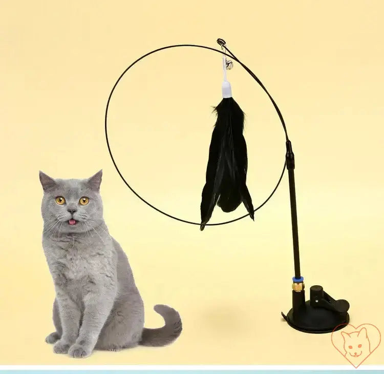 Interactive Feather Cat Wand with Suction Cup next to a curious grey cat on a pastel yellow background.