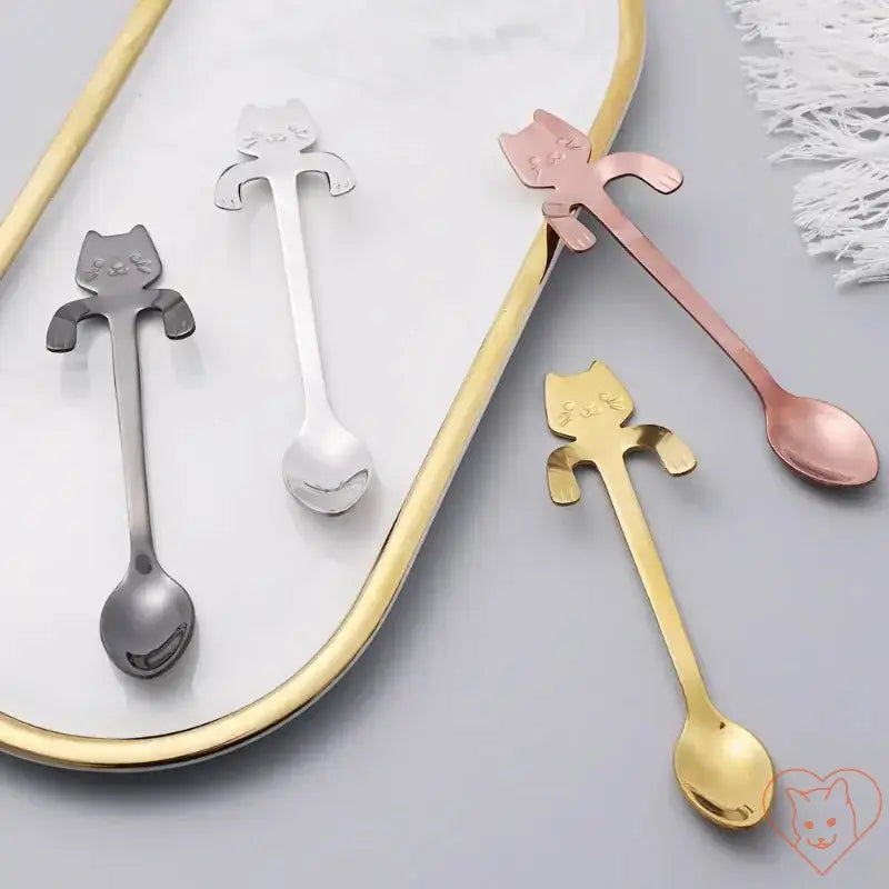 Three stylish Mini Cat Coffee Spoons in silver, gold, and rose gold on a decorative tray.