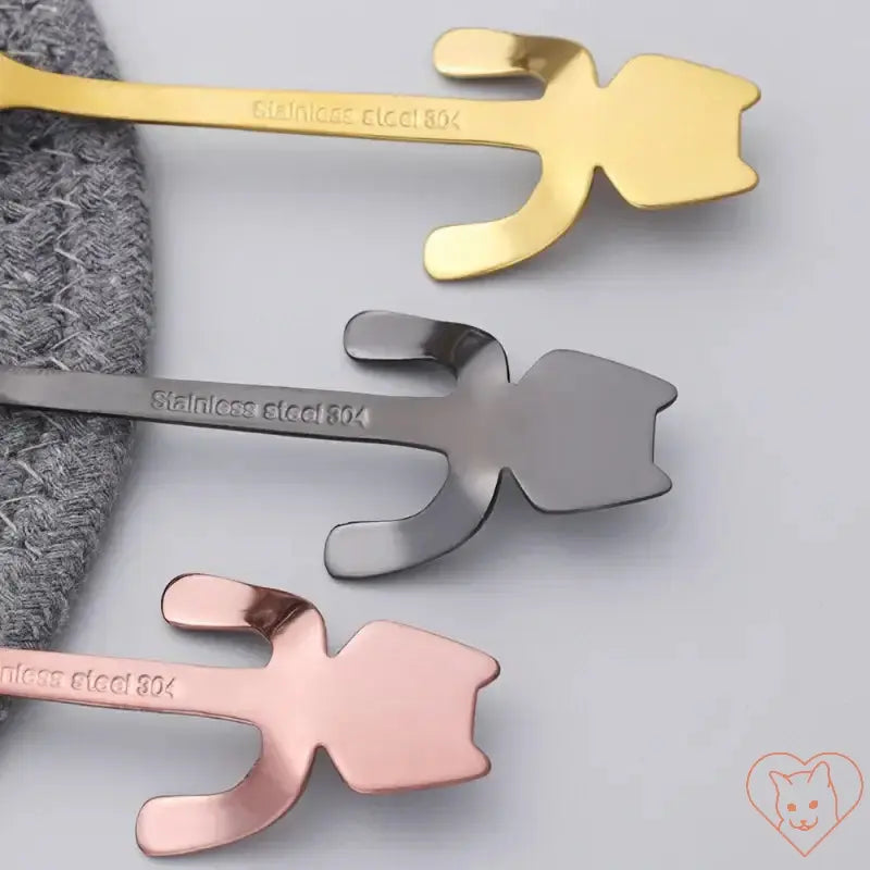 Mini Cat Coffee Spoons in gold, silver, and rose gold stainless steel designs on a gray fabric background.