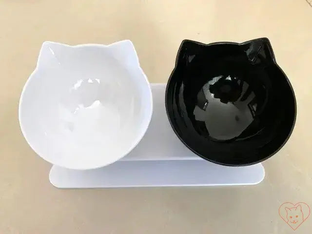 Non-slip double cat bowl with stand, featuring white and black cat-shaped bowls for stylish pet dining.