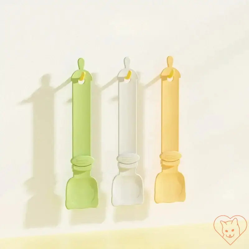 Multifunctional cat feeder spoons in green, white, and yellow for dispensing wet food and treats for pets.