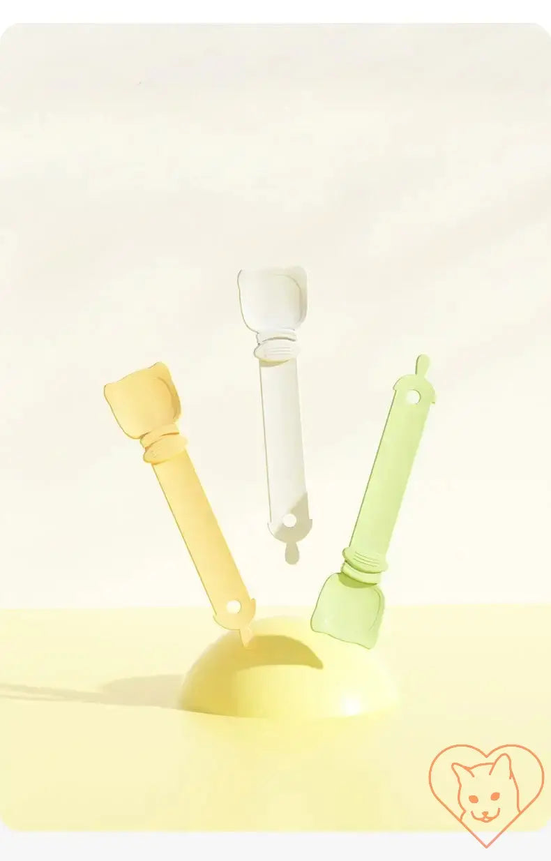 Multifunctional cat feeding spoons in yellow, green, and white, designed for dispensing wet food and treats for pets.