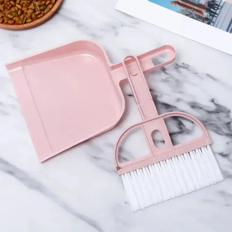 Small broom and dustpan set in pink, ideal for quick clean-ups of pet messes and litter spills.