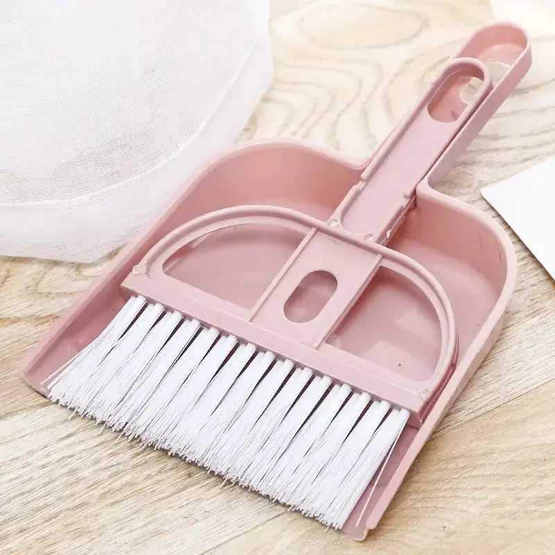 Close-up of a pink dustpan and broom set ideal for quick clean-ups of pet messes and everyday debris.