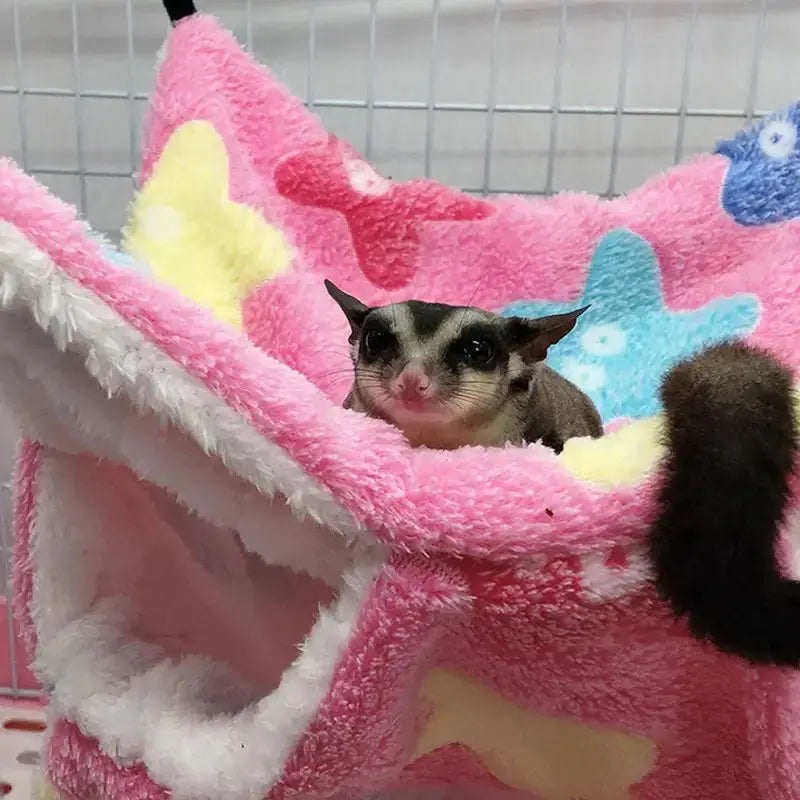 Cozy cat resting in a thick plush hanging tree bed made of soft coral fleece.