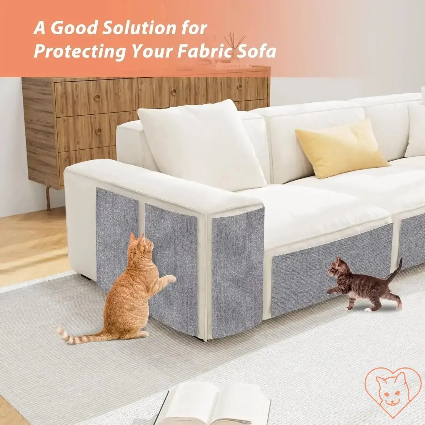 Two cats play near a self-adhesive scratching mat protecting a fabric sofa in a stylish living room.