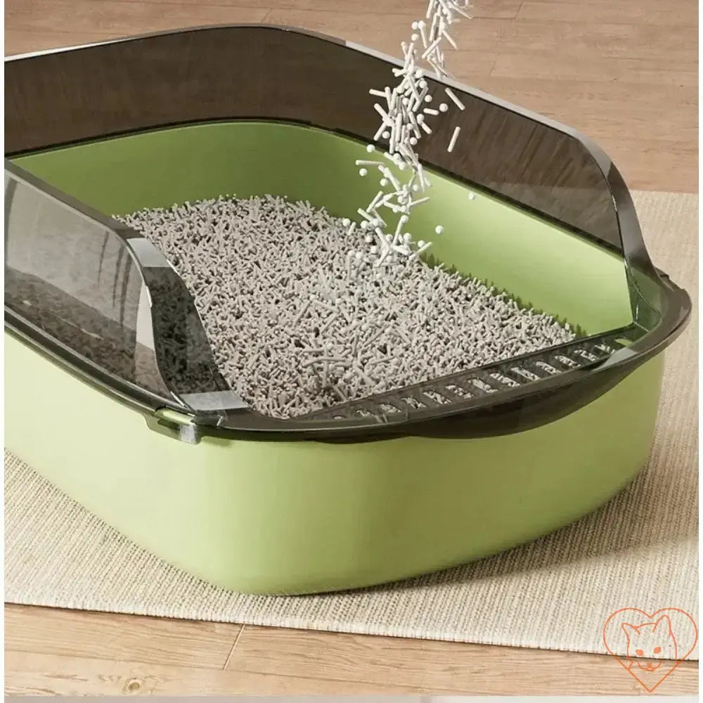 Semi-enclosed open cat litter box with high sides and gray litter being poured in.