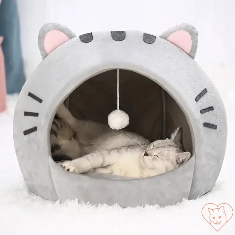 Cozy gray cat bed with ears, featuring a hanging toy, perfect for cats to relax and snooze comfortably.