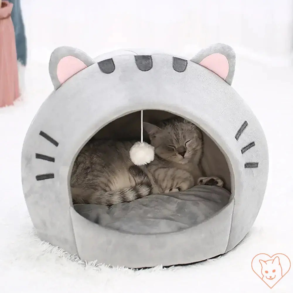 Cozy grey cat bed with cute ears, featuring a hanging toy, perfect for feline naps and relaxation.