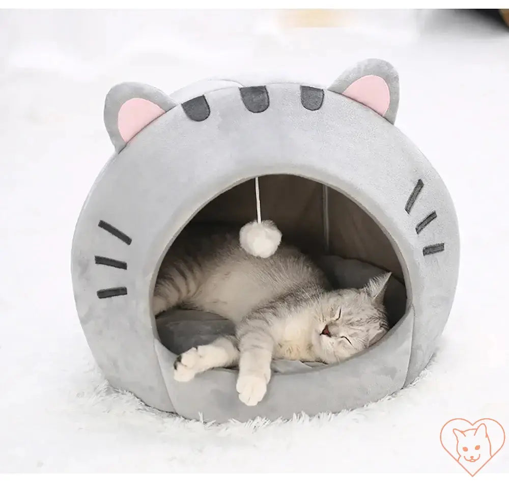 Cozy Super Cat Bed with hanging toy, featuring a sleeping cat in a cute cave design.