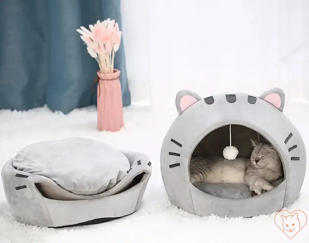 Cozy gray semi-covered cat bed with hanging toy and reversible cushion for pets.