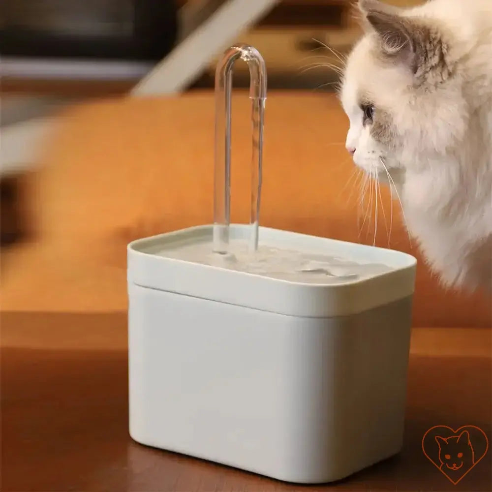 Ultra-Quiet 1.5L Cat Water Fountain with clear water flow and a curious cat, promoting hydration and health for pets.