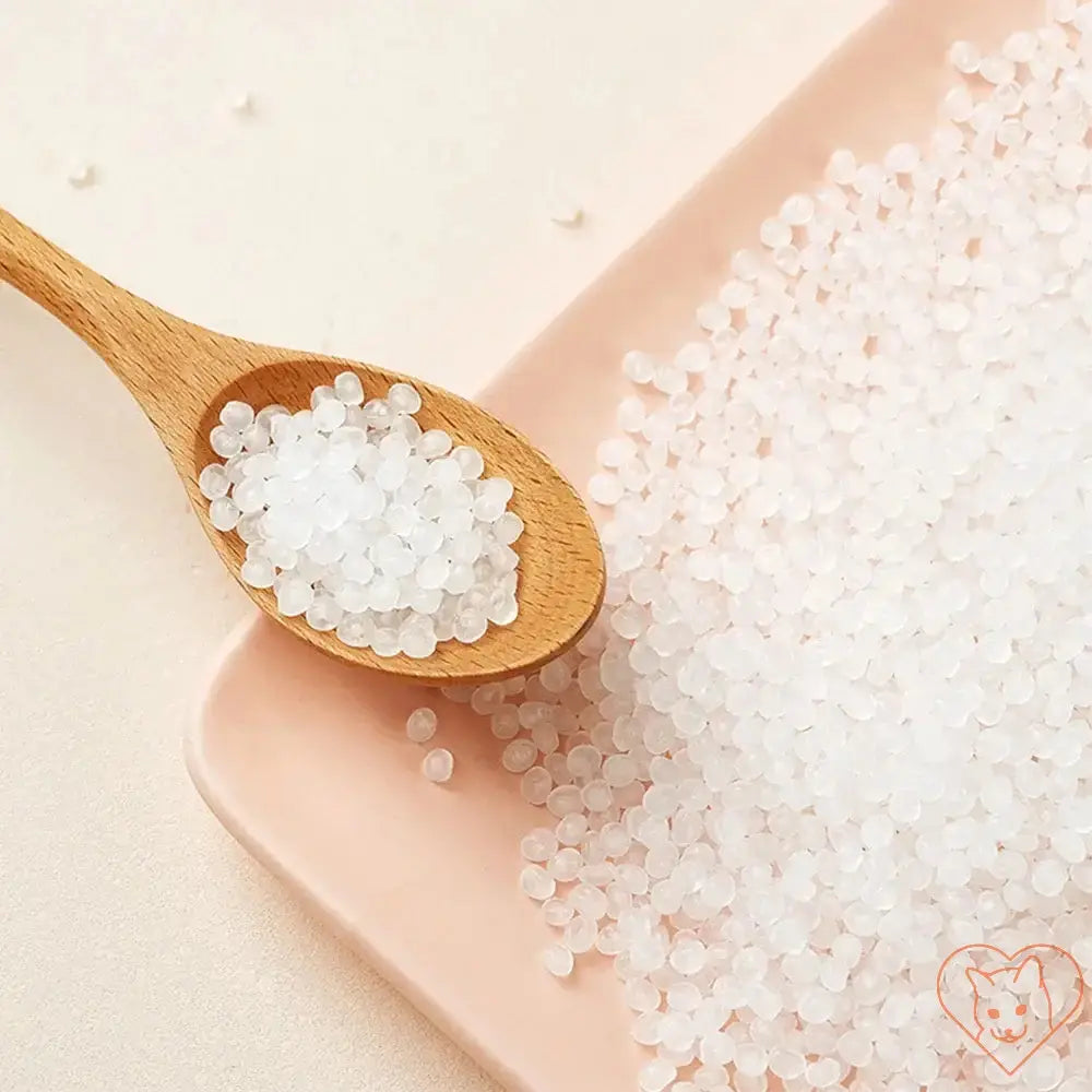 Wooden spoon with crystal-clear salt granules on a pink plate, showcasing a natural and organic look.