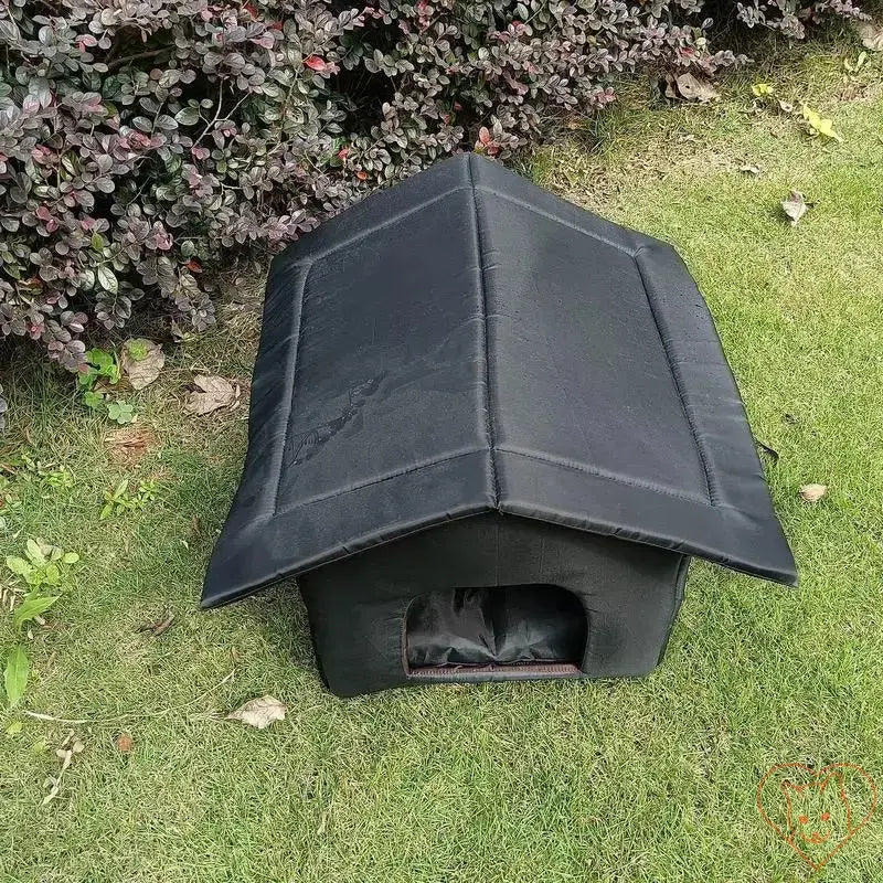 Waterproof outdoor cat house on grass, portable insulated pet shelter for warm and cozy protection.