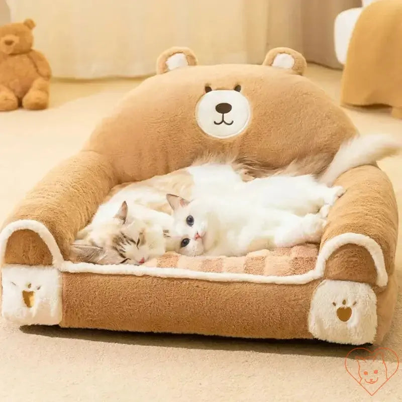 Two cats sleeping peacefully on a cozy winter plush cat bed designed like a bear sofa.