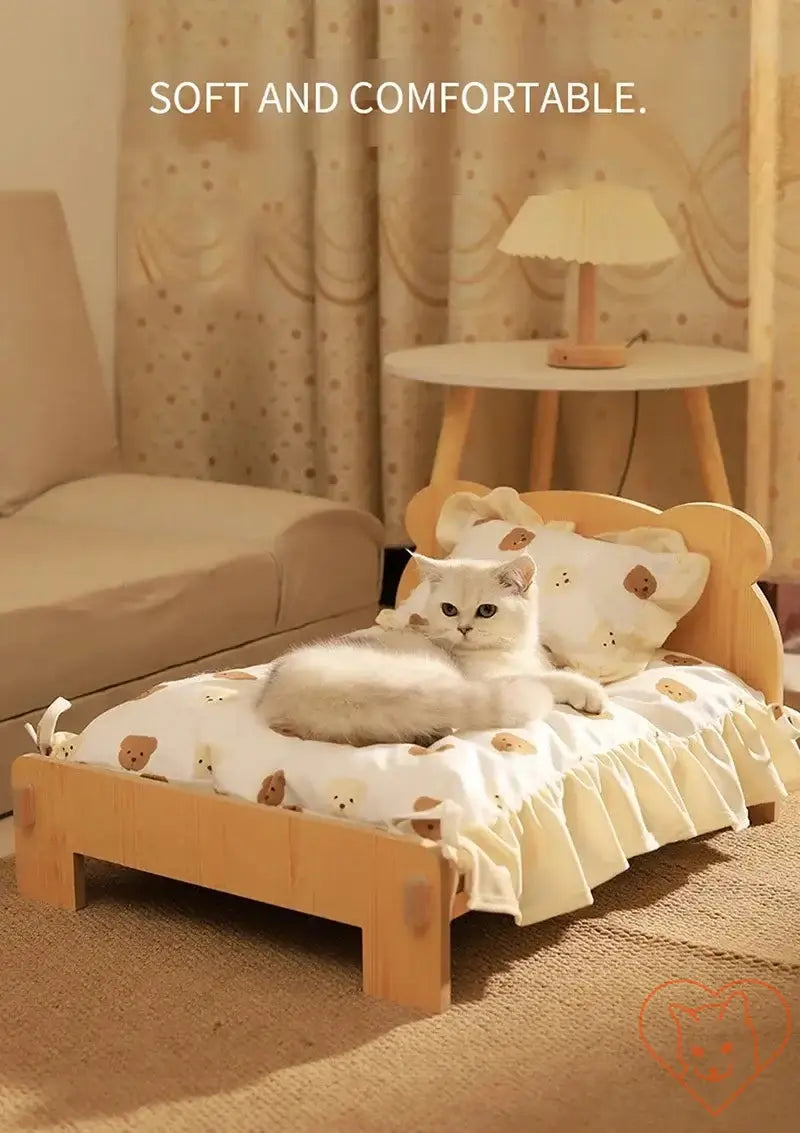 Cozy wooden cat bed with teddy bear pattern and a cat lounging on it, featuring soft cushions and a modern design.